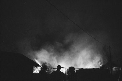 Low angle view of silhouette people against sky at night