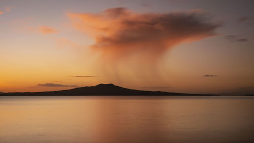 Scenic view of silhouette mountains against orange sky