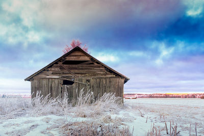 Built structure on snow covered landscape against sky