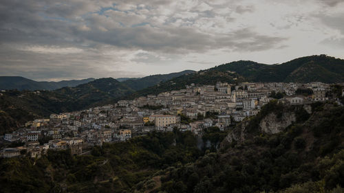 Buildings in town against cloudy sky