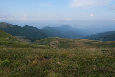 Scenic view of field and mountains against sky