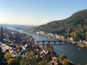 High angle view of river amidst buildings in town against clear sky