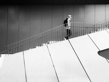 Low angle view of man on staircase against wall