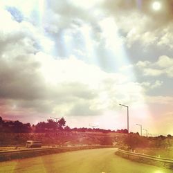 Road against cloudy sky at sunset