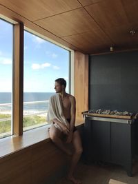 Young man looking through window