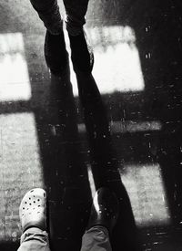 Low section of man standing on puddle