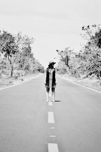 Rear view of woman walking on road