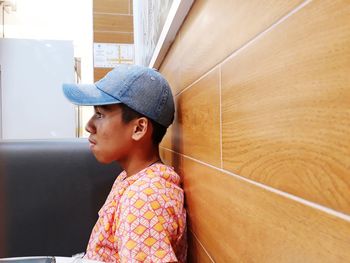 Portrait of boy looking away while standing against wall