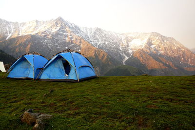 Tent in field with mountain range in the background