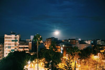 Illuminated buildings in city against sky