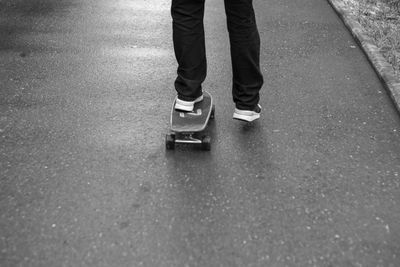 Low section of man walking on road