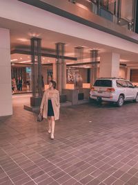 Rear view of woman standing in illuminated building