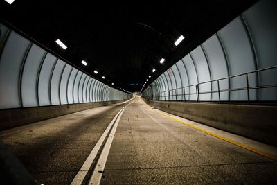 Road in illuminated empty tunnel