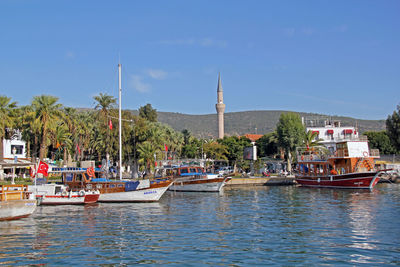 Boats moored in river against blue sky