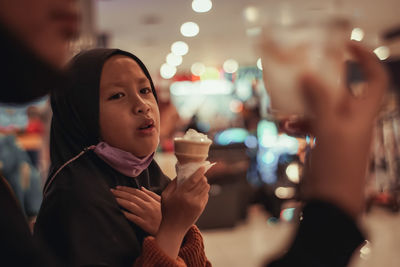 Portrait of young woman holding ice cream