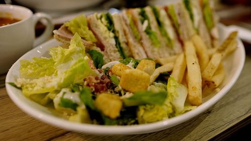 Close-up of sandwiches with french fries served in bowl on table