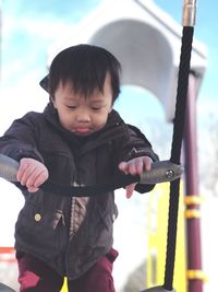 Low angle view of boy climbing on ropes at playground