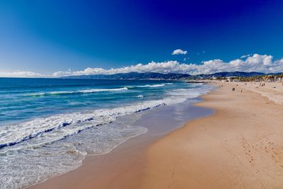 Scenic view of beach against blue sky