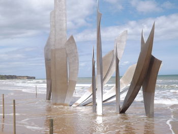 Close-up of omaha beach memorial by sea against sky