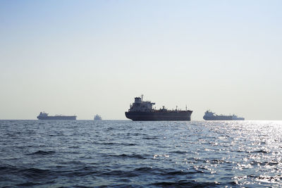 Ship sailing on sea against clear sky