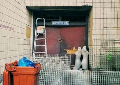 Metal grates and garbage bin against building