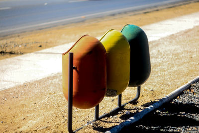 Close-up of bins on beach against sky