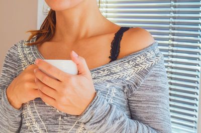 Midsection of woman having coffee