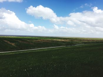 Scenic view of field against cloudy sky