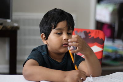 Close-up portrait of boy sitting at home