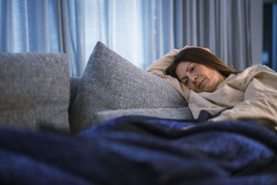 Ill woman lying on sofa