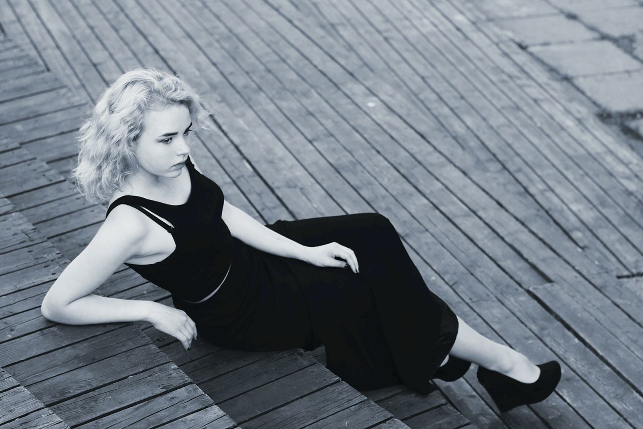 YOUNG WOMAN SITTING ON SEAT