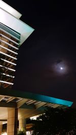 Low angle view of illuminated buildings against sky at night