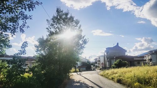 Road amidst trees against sky