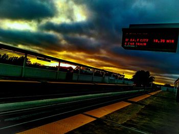 Train on railroad station platform against cloudy sky