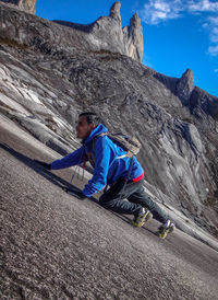 Tilt shot of man climbing mountain