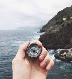 Close-up of hand holding rock in sea