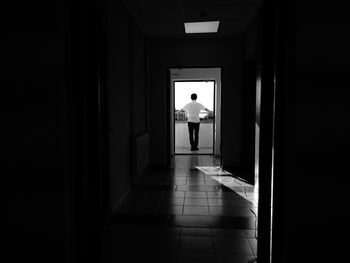 Rear view of man walking in corridor of building