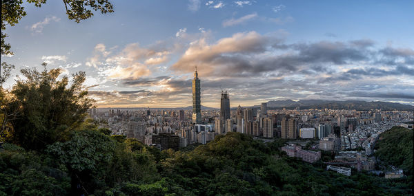 View of cityscape against cloudy sky