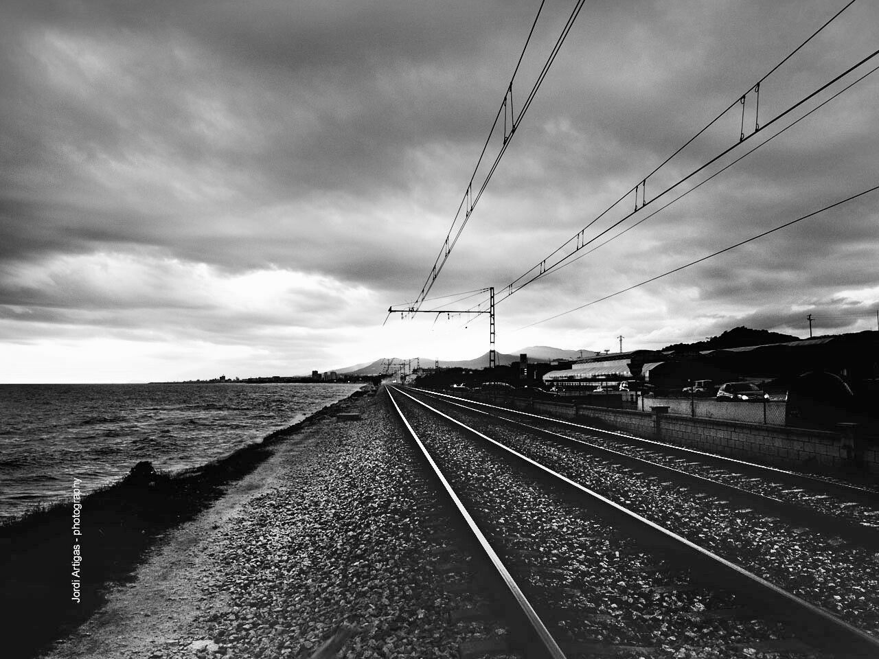 sky, cloud - sky, railroad track, transportation, water, the way forward, cloudy, rail transportation, diminishing perspective, cloud, built structure, vanishing point, architecture, connection, sea, overcast, public transportation, travel, day, outdoors