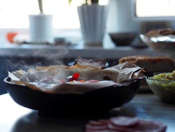 A frying pan just removed from the oven with baked potatoes with vegetables and chum 