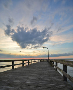 Pier over sea against sky during sunset