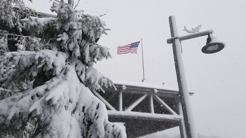 Low angle view of flag against snow covered landscape