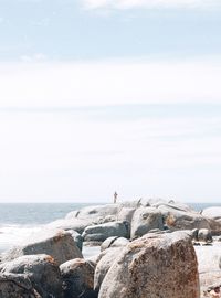 Rear view of man standing on beach against clear sky