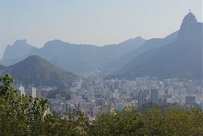Aerial view of city and mountains against clear sky