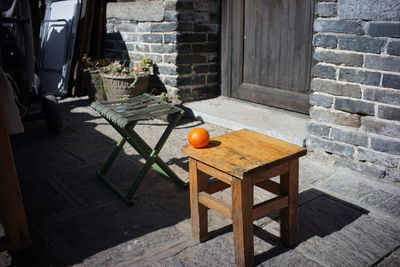 Table and chairs against orange wall