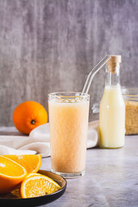 Vegetarian smoothie made from rice milk and orange in a glass on the table vertical view