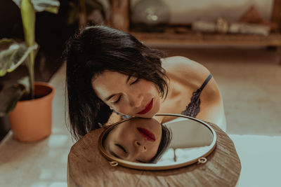 Portrait of young woman lying down at home