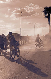 People riding motorcycle on road against sky