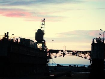 Construction site against sky at sunset