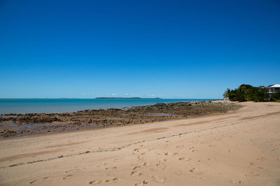 Scenic view of beach against clear blue sky